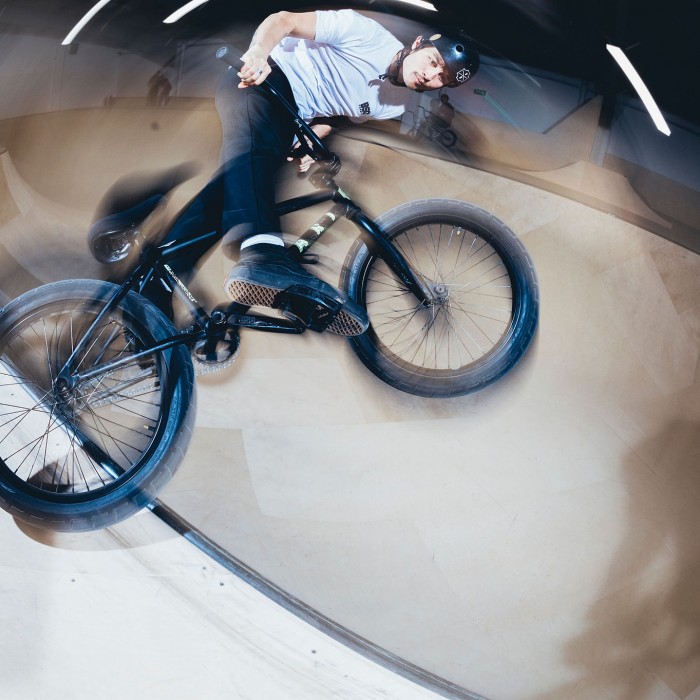 Guy on bike on the bowl doing trick